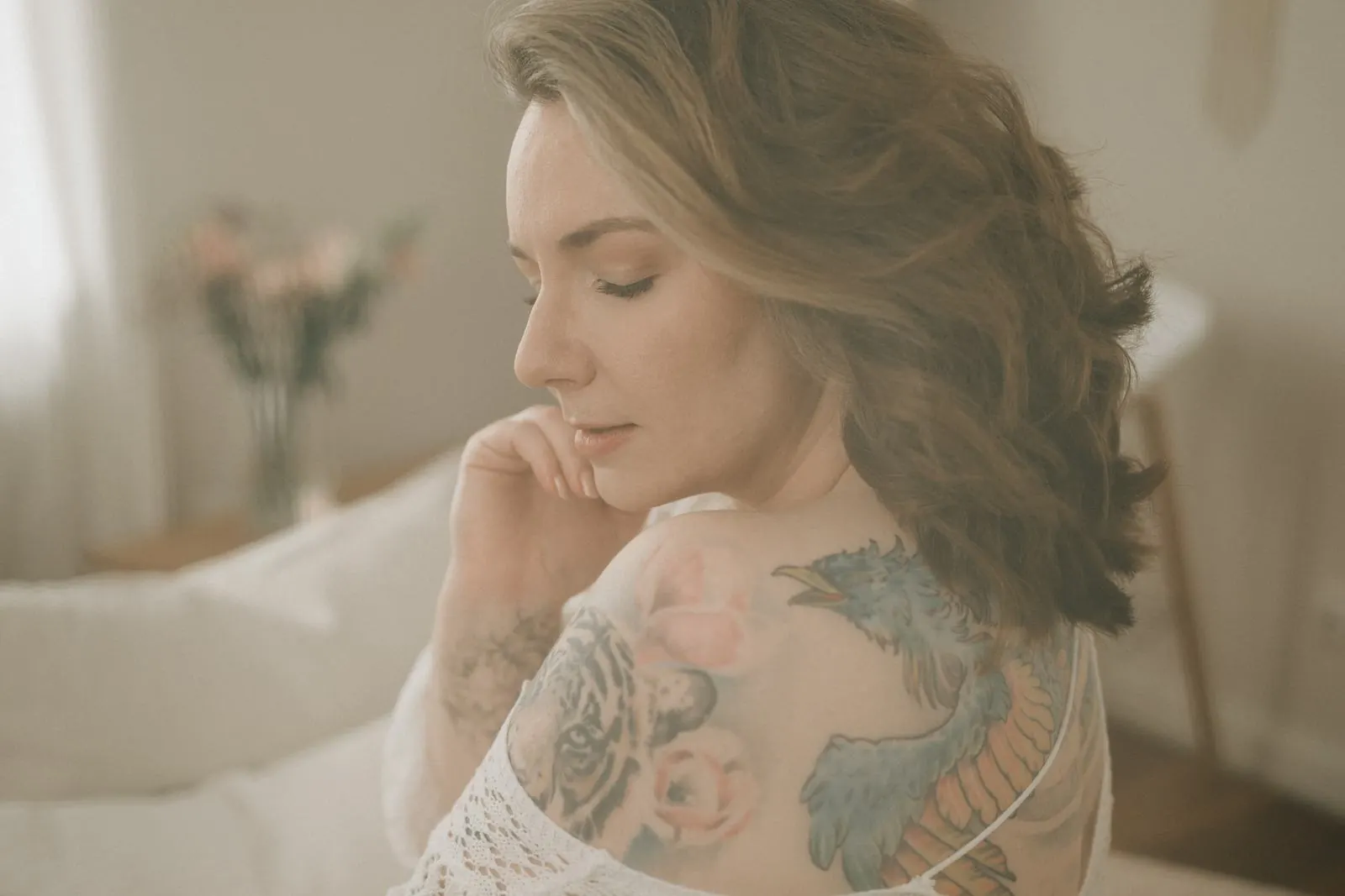 Frau mit geschlossenen Augen, Tattoo auf der Schulter, zartes Boudoir im Studio Jork