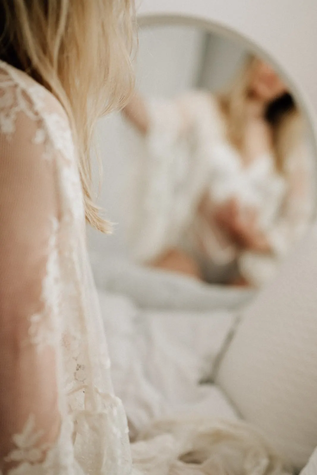 Detail: blondes Haar und Spitze, im Hintergrund ein Spiegel
