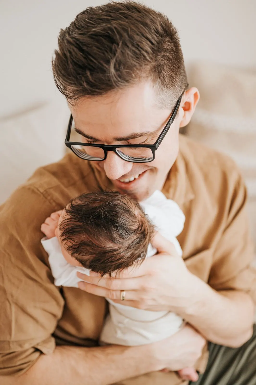 Vater hält sein Neugeborenes liebevoll im Arm, Neugeborenenfotografie im Studio Jork