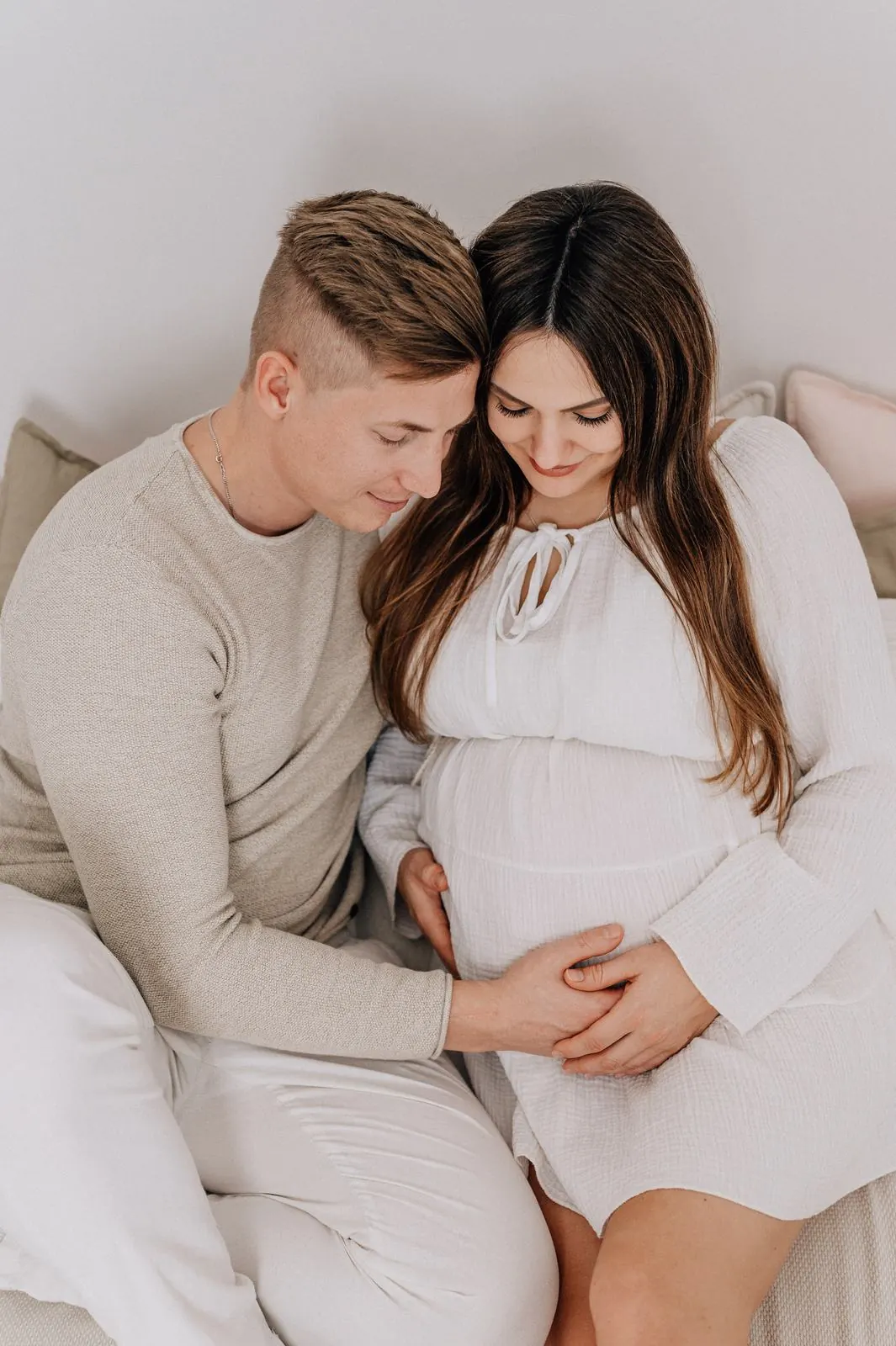 Paar hält gemeinsam den Babybauch, Schwangerschaftsshooting Julia Aßmann