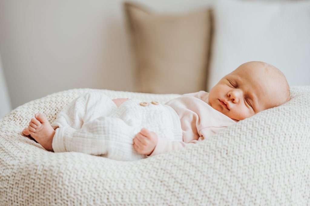 Ganzkörperaufnahme vom schlafende Baby in heller Umgebung beim Fotoshooting mit Neugeborenenfotografin Julia Aßmann im Fotostudio in Jork und Umgebung